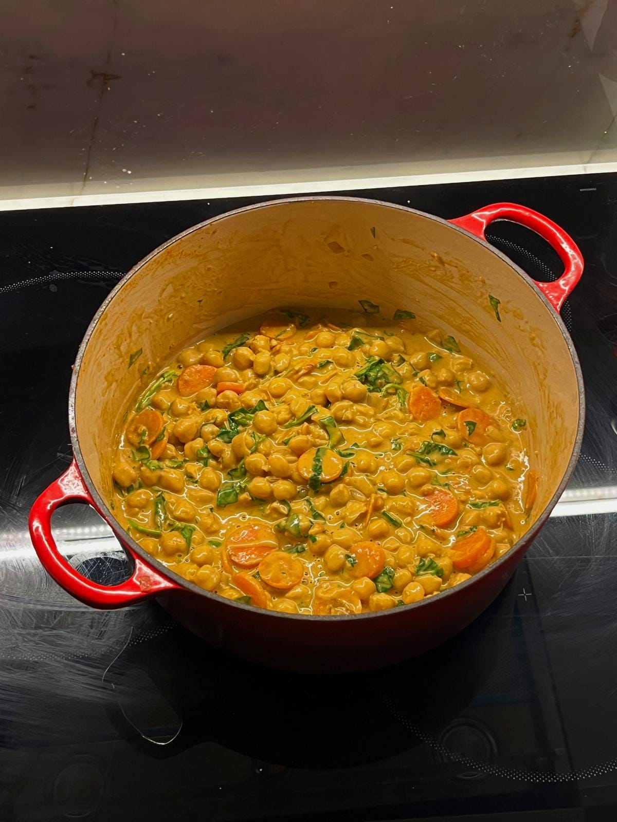 Chickpea and spinach curry in a red cast iron pot