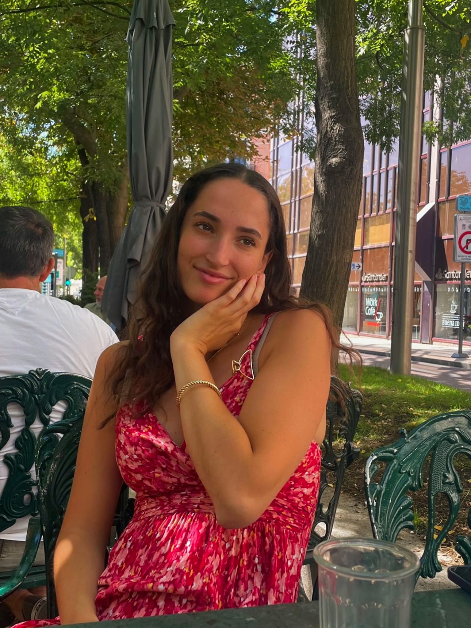 Sofia Hall smiling at an outdoor cafe table in Madrid
